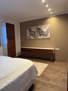 a bedroom with a bed and a desk and two paintings at Appartement Muller-Mayer in Weissensee