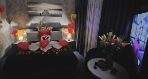a bedroom with a bed with hearts and a vase of flowers at Apartament WODNY RAJ Z BASENEM SAUNĄ JACUZZI NA WYŁĄCZNOŚĆ in Rzeszów
