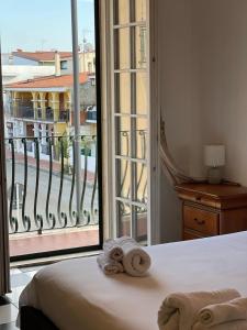 a bedroom with a bed and a large window at Gió guest house in La Caletta