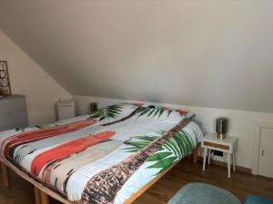 a bedroom with a bed with a colorful blanket on it at Vacanzamare in Wenduine
