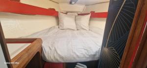 a small bedroom with a bed with white sheets at Ma Belle Lana, Chantereyne Marina in Cherbourg en Cotentin
