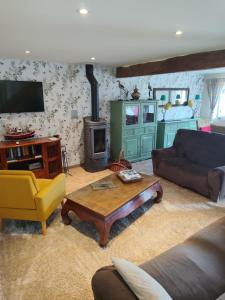 a living room with a couch and a wood stove at Location de La Ferme De Kerraoul in Combrit