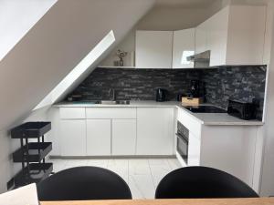 a kitchen with white cabinets and a staircase at Vacanzamare in Wenduine +6 photos