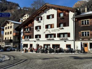 a group of people sitting outside of a building at Hotel Suretta in Splügen