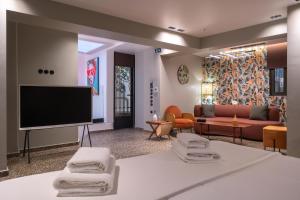 a living room with a flat screen tv and a couch at Athens Retro in Athens