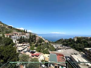 a view of a city with the ocean in the background at Taormina Sky View in Taormina