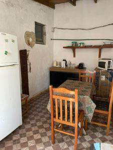 a kitchen with a table and a white refrigerator at Inactivo in Chuy +7 photos