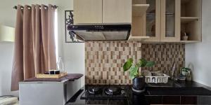 a small kitchen with a stove and a microwave at Soft Reset Room by YOMAIN in Kemirimuka Tiga