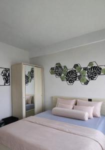 a bedroom with a large bed and a mirror at Soft Reset Room by YOMAIN in Kemirimuka Tiga