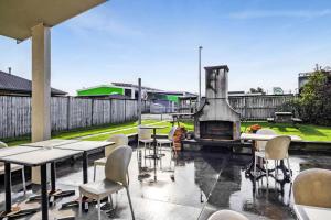 a patio with tables and chairs and a fireplace at Kaponga Hotel in Kaponga