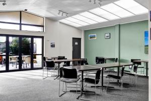 a large room with tables and chairs and windows at Kaponga Hotel in Kaponga