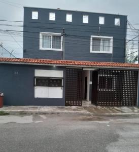 a blue house with white doors and a gate at En la 96 in Cancún +2 photos
