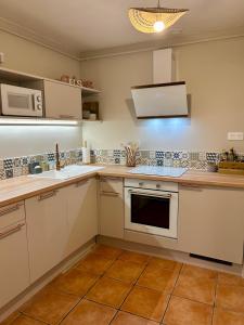 a kitchen with white cabinets and a stove top oven at le Roy de coeur in Riquewihr +14 photos