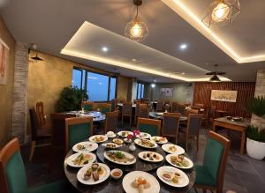 a dining room with a table with plates of food at Cloud Chaser Hotel in Sapa
