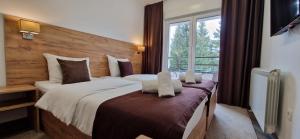 a hotel room with a large bed and a window at Apartments & rooms Concept Nordica in Žabljak