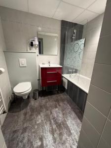 a bathroom with a red sink and a toilet at Hôtel - Restaurant Eugenie in Pontorson +68 photos