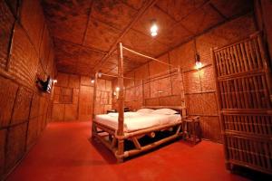 a bedroom with a bed in a wooden room at Bali Bamboo Resort in Padinjarathara +5 photos