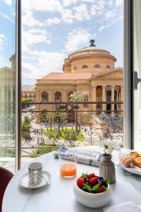 a table with food and a view of a building at Palazzo Sovrana Serviced Luxury Apartments in Palermo