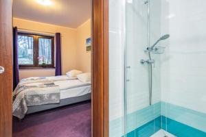 a bedroom with a bed and a glass shower at Apartamenty Niegocin in Wilkasy +69 photos
