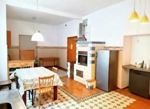a kitchen with a table and a kitchen with a refrigerator at Zemlinsky Loft Bunk Room in Payerbach