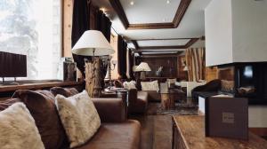 a living room with couches and a fireplace at Hotel Tsanteleina in Val-d'Isère