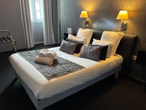 a large bed with two towels on top of it at Hôtel - Restaurant Eugenie in Pontorson