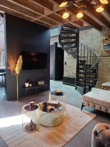 a living room with two tables and a fireplace at L'entrepôt Spadois in Spa