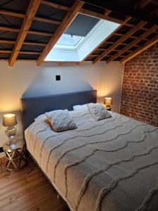 a bedroom with a large bed in a brick wall at L'entrepôt Spadois in Spa