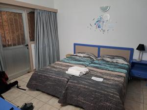 a bedroom with a bed with towels on it at C & A Hotel Apartments in Polis Chrysochous