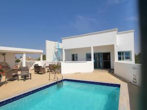 a house with a swimming pool in front of it at Le Dolmen de Mbour in Mbour