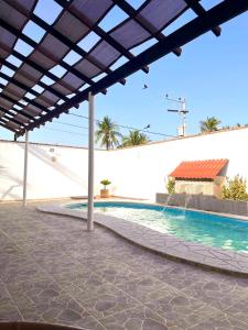 an outdoor swimming pool with a large pergola at Baru chachalacas in Chachalacas +13 photos
