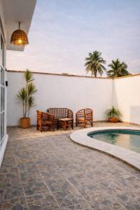 a patio with two chairs and a swimming pool at Baru chachalacas in Chachalacas