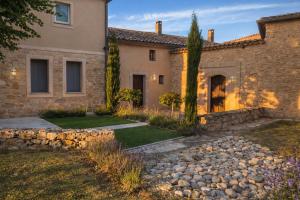 a stone house with a garden and a stone driveway at La Grange Blanche in Sault-de-Vaucluse