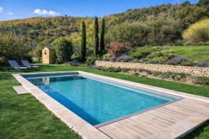 a swimming pool in the yard of a house at La Grange Blanche in Sault-de-Vaucluse