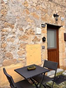 a table and chairs in front of a stone building at La Casetta in Grotte di Castro +3 photos