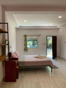 a bedroom with a large bed and a window at P&G leampom hotel in Ban Chao Nam