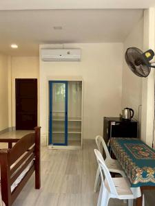 a dining room with a table and a blue door at P&G leampom hotel in Ban Chao Nam