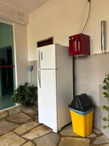 a white refrigerator and a trash can next to a building at Pouso do Carmo in Pirenópolis