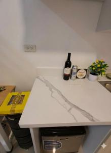 a white counter top with a bottle of wine on it at Urdaneta City Modern Condo in Bayaoas
