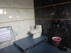 a bathroom with a toilet and a trash can at Golden Oriole Homestay in Srīvardhan