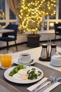 a table with a plate of food and a cup of coffee at Hotel Nordkap in Karlshagen