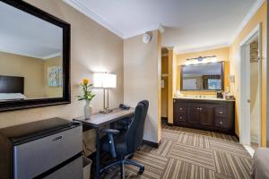 a hotel room with a desk and a mirror at West Point Motel in Highland Falls