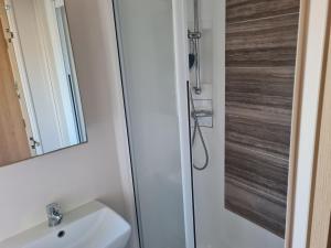 a bathroom with a shower and a sink at Lilly Luxury Hot Tub Caravan - theluxurycaravan - GV109 Grange Leisure Park in Mablethorpe +13 photos