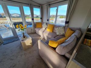 a living room with two couches and a table at Lilly Luxury Hot Tub Caravan - theluxurycaravan - GV109 Grange Leisure Park in Mablethorpe