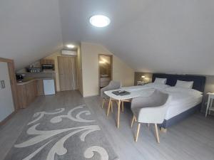 a bedroom with a bed and a table and chairs at Anton Apartmanház in Balatonfüred +35 photos