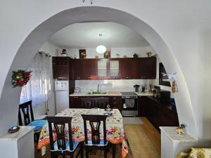 a kitchen with a table with chairs and an archway at Petrit apartament in Qeparo
