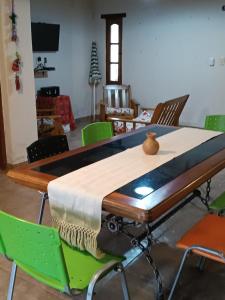 a dining room table with green chairs around it at Casa Verdes del Malka in Tilcara