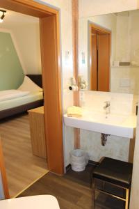 a bathroom with a sink and a room with a bed at Gästehaus Niemerg in Warendorf +61 photos