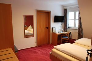 a hotel room with two beds and a desk and a mirror at Gästehaus Niemerg in Warendorf