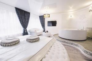 a bedroom with a large bed and a tub at Jacuzzi Romantic Apartment in Klaipėda